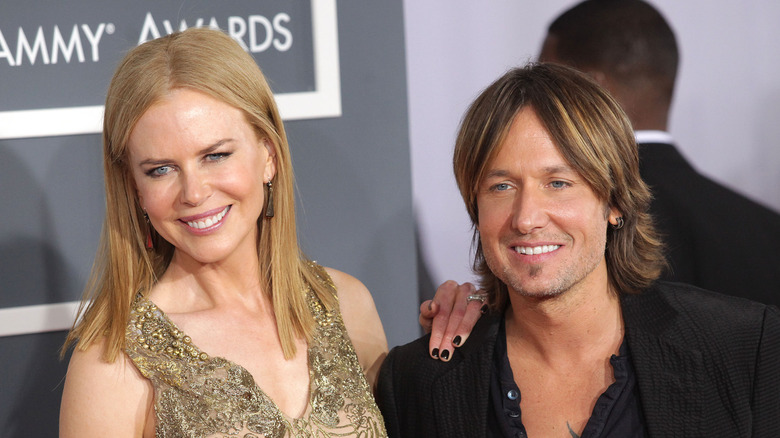 Nicole Kidman posing with her hand on Keith Urban's shoulder on the Grammys red carpet