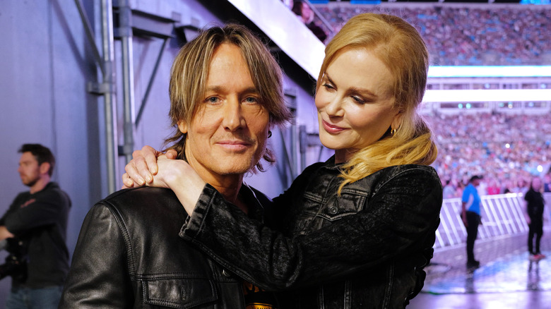 Nicole Kidman gazing at Keith Urban with her arms around his neck as he looks at the camera