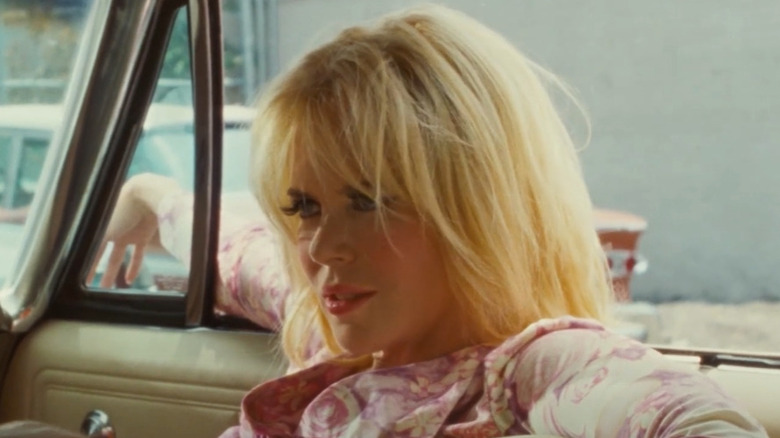 Nicole Kidman sitting in a car with long, straight blond hair with bangs in The Paperboy