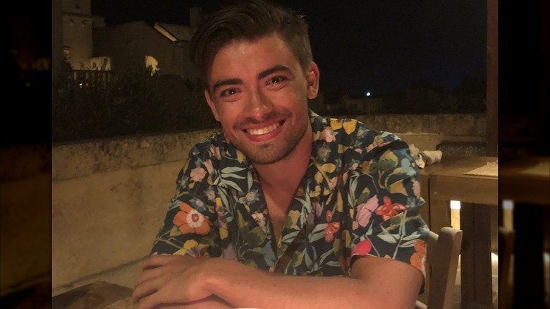 Michael Consuelos smiling and seated at a table.