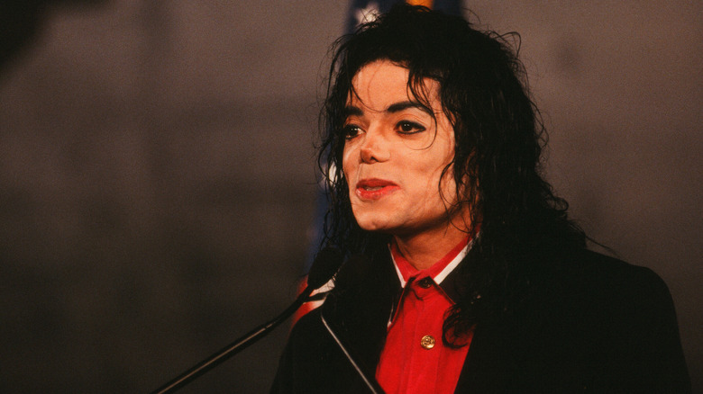 Michael Jackson speaking into a microphone at a "Heal the World" press conference.