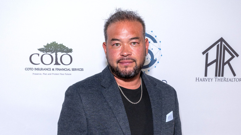 Jon Gosselin posing at an event in a grey blazer with a black shirt underneath