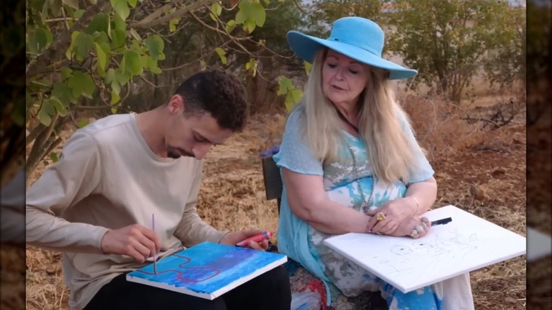 Debbie Aguero and Oussama Berber speak outside while painting.