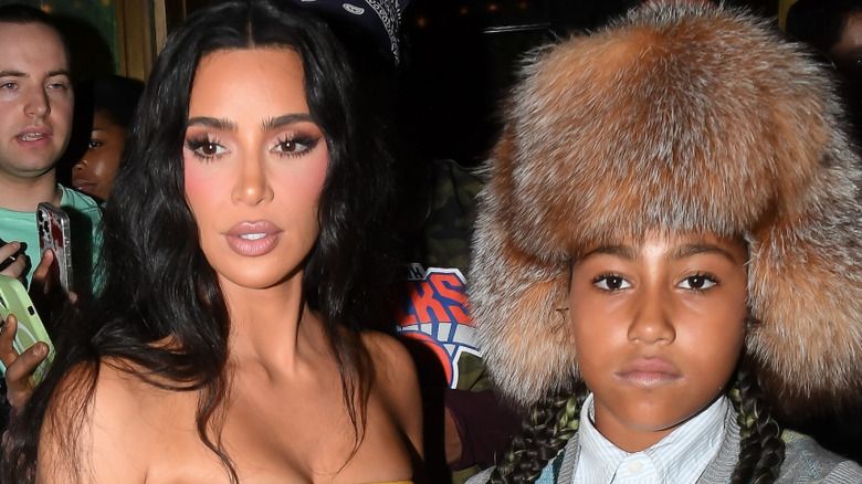 North West exits a car ahead of her mother, Kim Kardashian.