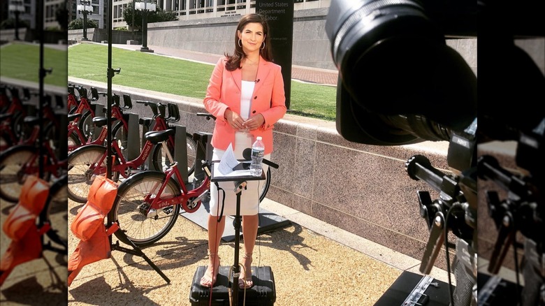 Kaitlan Collins standing in front of camera and bikes