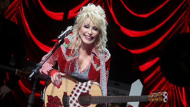 Dolly Parton smiling while performing onstage