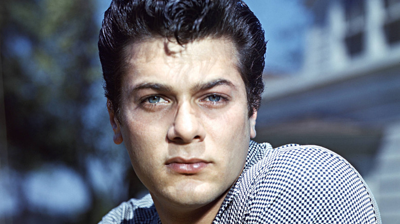 Tony Curtis posing outside with a stern expression
