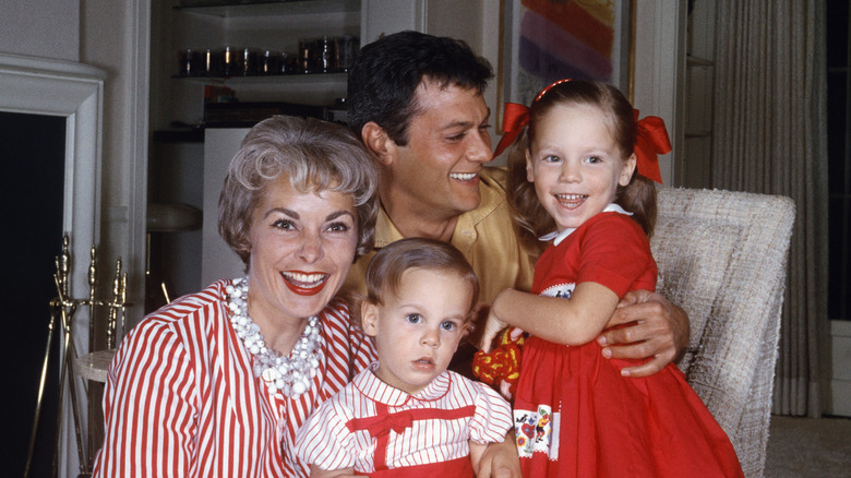 Janet Leigh, Tony Curtis, Jamie Lee Curtis, and Kelly Lee Curtis posing in a living room