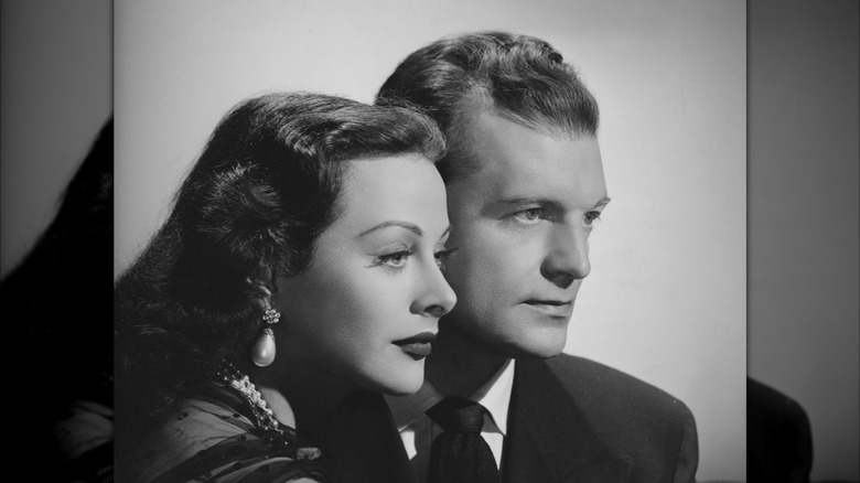Hedy Lamarr leans on John Loder as the couple fixes their gaze downward.