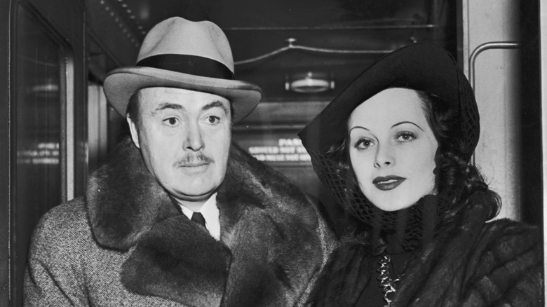 Gene Markey stares downward while Hedy Lamarr flashes a gentle smile.