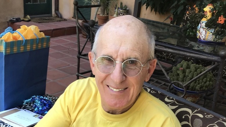 Michael Payne sitting on a patio wearing a yellow t-shirt
