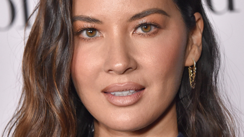Olivia Munn poses in gold earrings