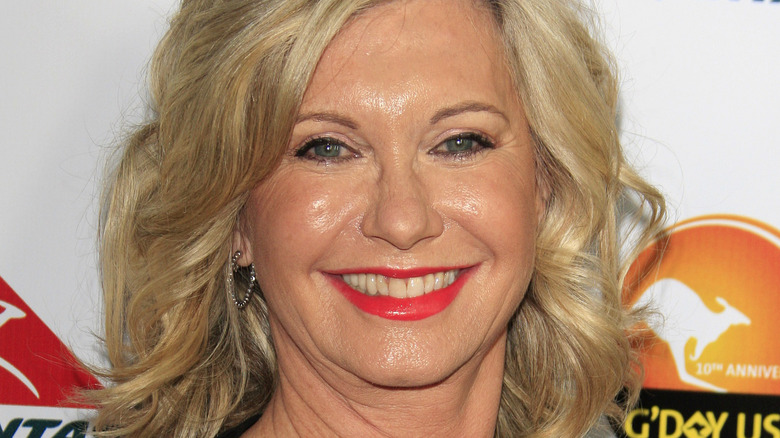 Olivia Newton-John wears bright red lipstick