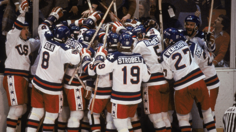 Mike Pavelich and Bob Suter with fellow hockey players, cheering