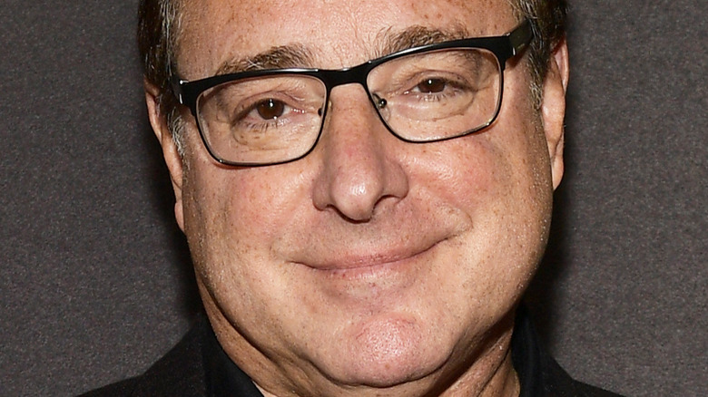 Bob Saget wears black-rimmed glasses