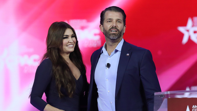 Kimberly Guilfoyle smiling; Donald Trump Jr. standing