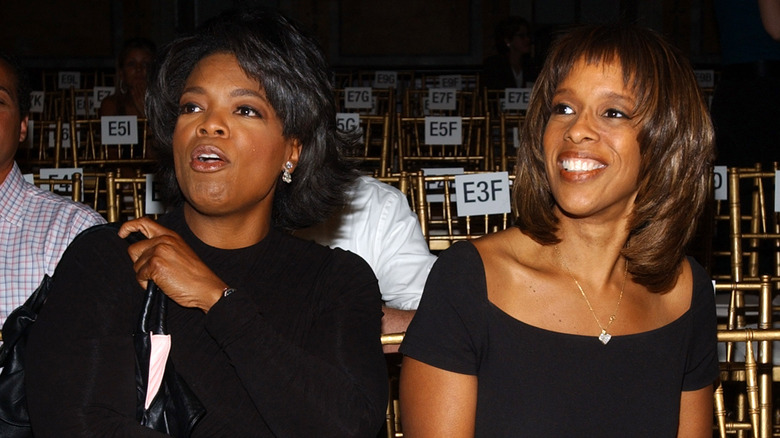 Oprah Winfrey sitting with Gayle King smiling
