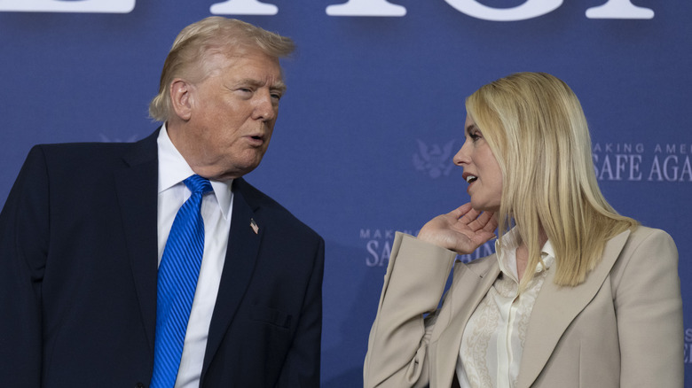 Donald Trump leaning over to speak to Pam Bondi