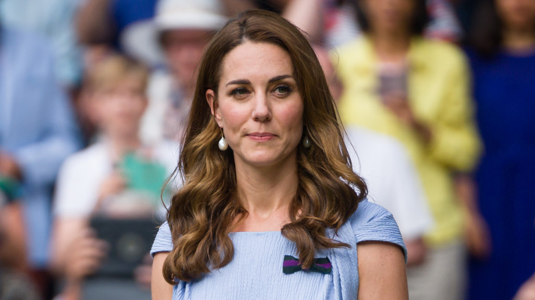 Kate Middleton wearing a blue dress with a black bow