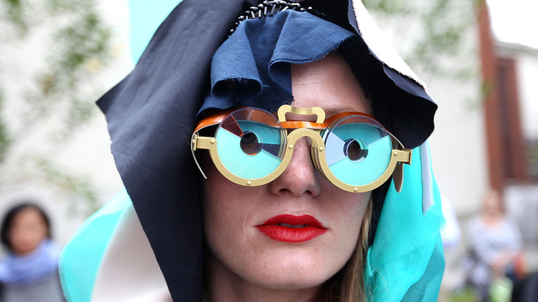 Woman wearing crazy colored glasses and head dress