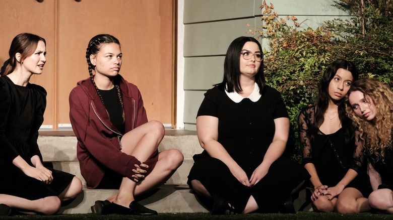 Euphoria cast members sitting on grass outside house