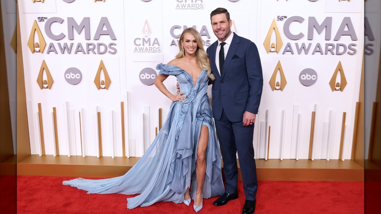 Carrie Underwood flashes a smile while posing alongside Mike Fisher.