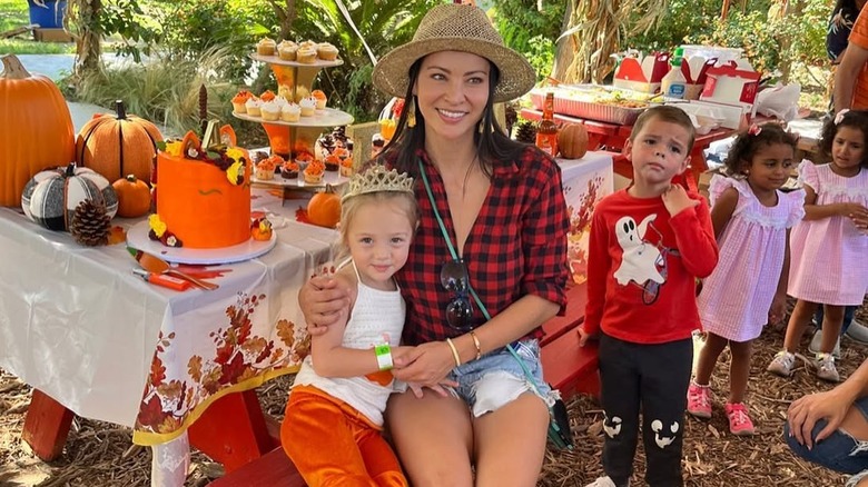 Varunie Vongsvirates and daughter Lyla Aranya Wilson sitting at a picnic table at a fall-themed birthday party.