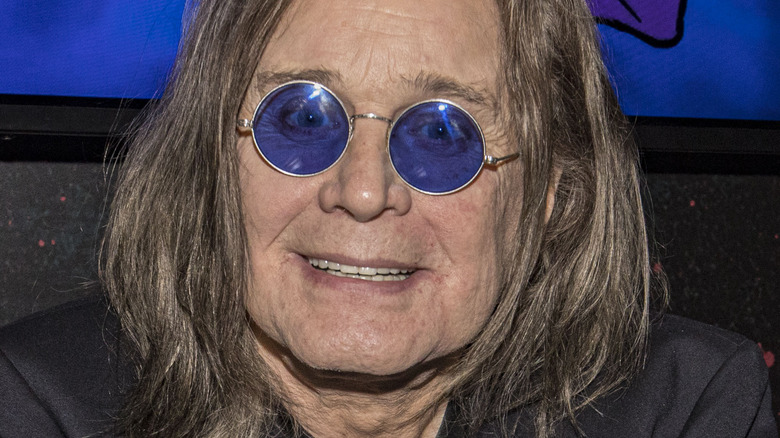 Ozzy Osbourne smiling round blue glasses