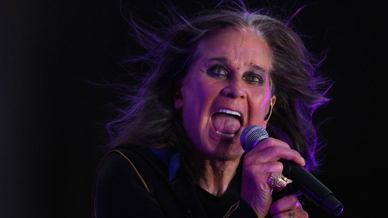 Ozzy Osbourne performing onstage with his hair blowing in the wind