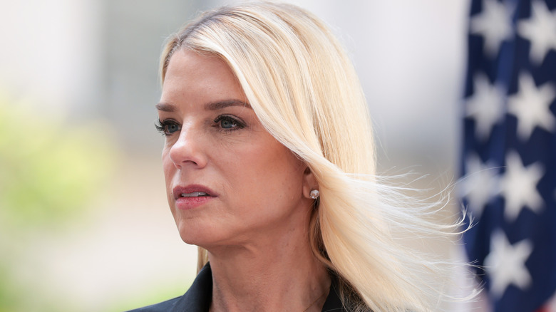 Pam Bondi at a press conference with her hair blowing in the wind