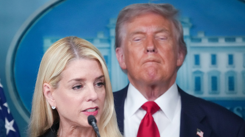 Donald Trump stands behind Pam Bondi while she speaks