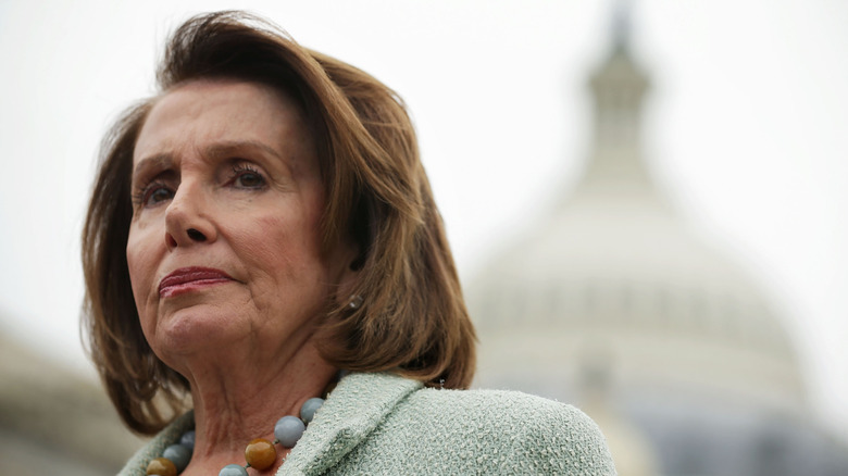 Nancy Pelosi listening during a news conference