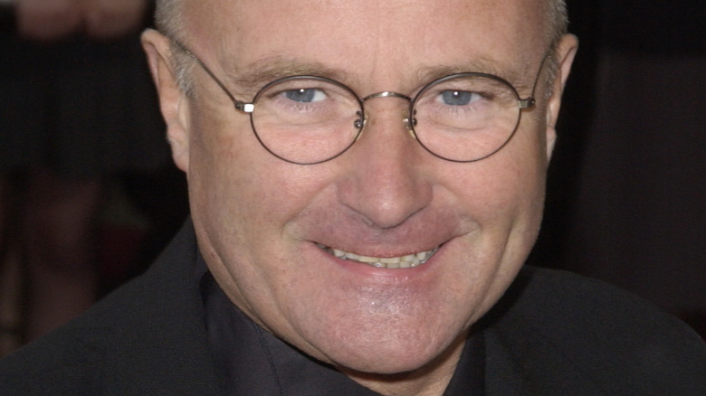 Phil Collins poses in round-frame glasses