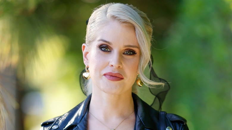 Kelly Osbourne wears heart-shaped earrings and her hair pulled back.