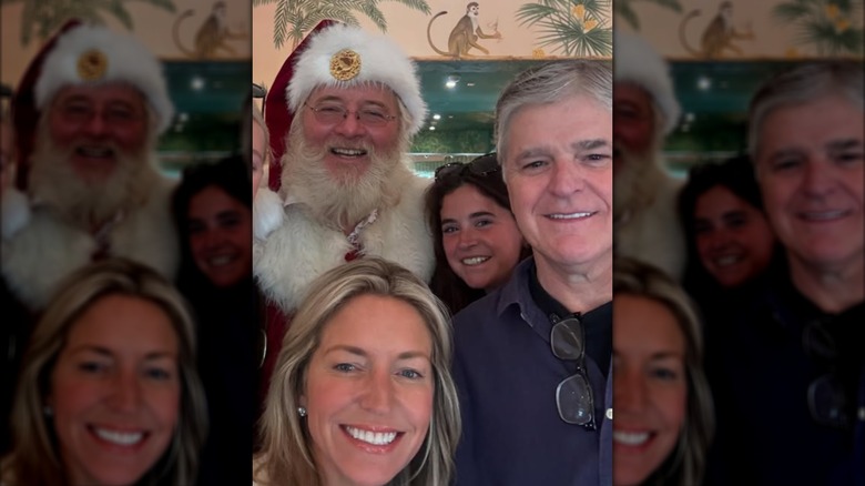 Ainsley Earhardt, Sean Hannity and his daughter posing with Santa Claus.