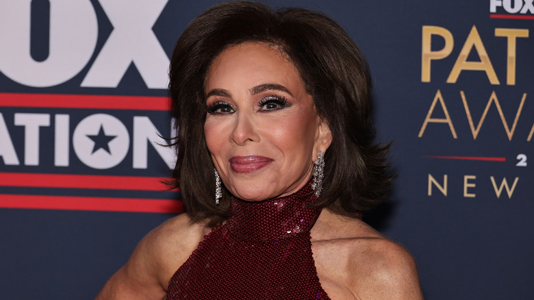Jeanine Pirro posing at a FOX event in a shoulderless top