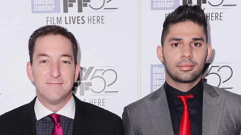 Glenn Greenwald and David Miranda in front of a step-and-repeat