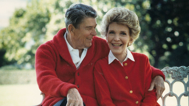 Ronald and Nancy Reagan sitting together on a bench