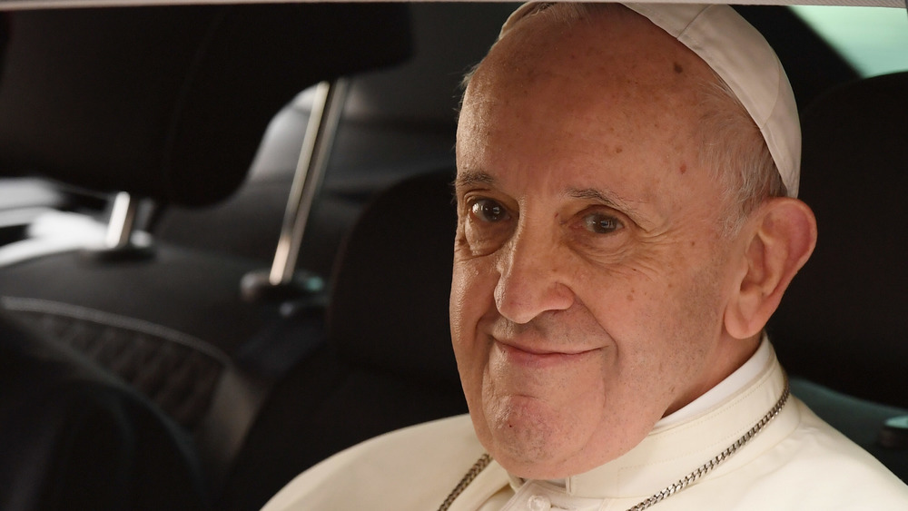 Pope Francis smiling in a car
