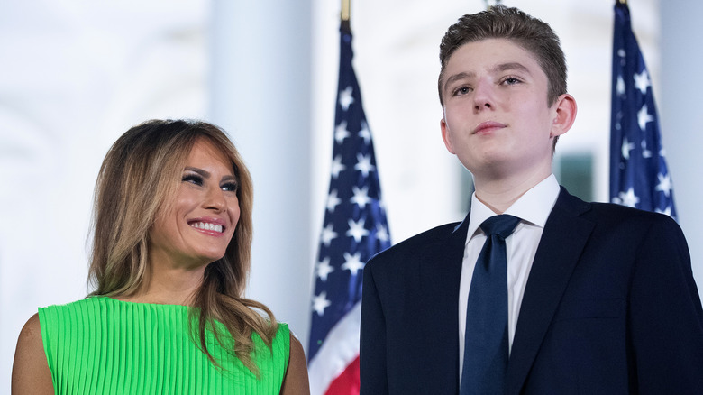 Barron Trump stands next to Melania Trump wearing tie