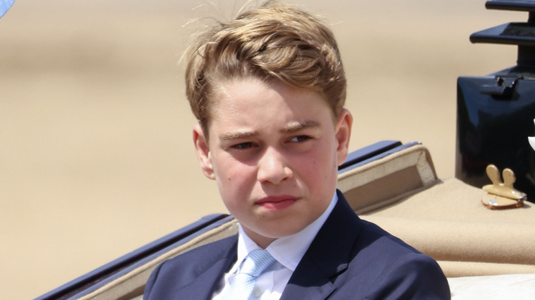 Prince George rides in a carriage.