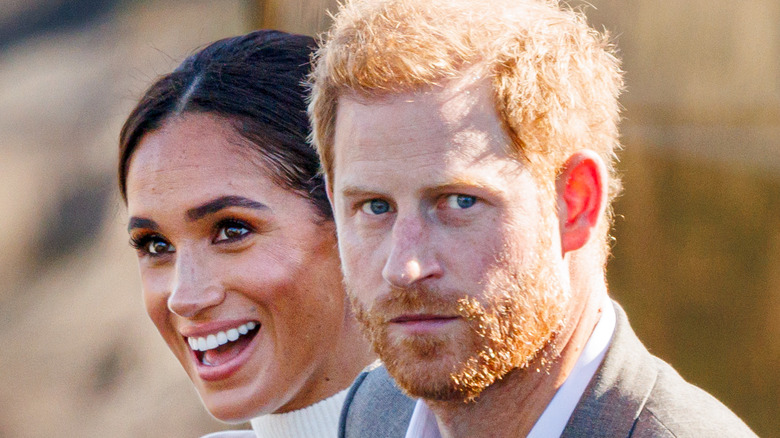 Meghan Markle smiling, Prince Harry looking worried