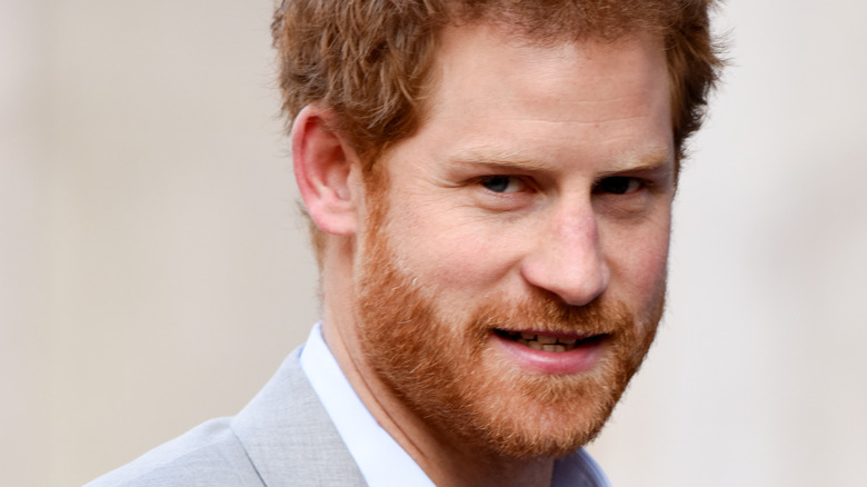 Prince Harry poses in a light gray suit.