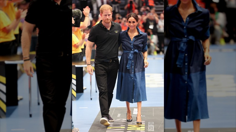 Prince Harry and Meghan Markle walking while embracing in a sports arena.