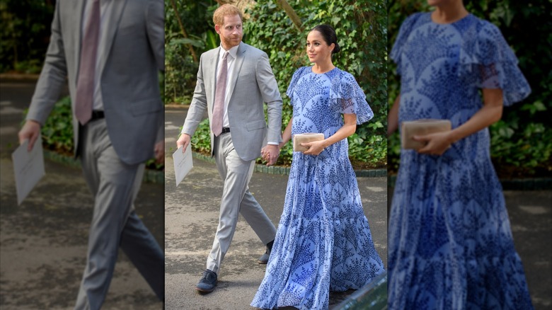Prince Harry and Meghan Markle holding hands while walking outside with vegetation behind them.