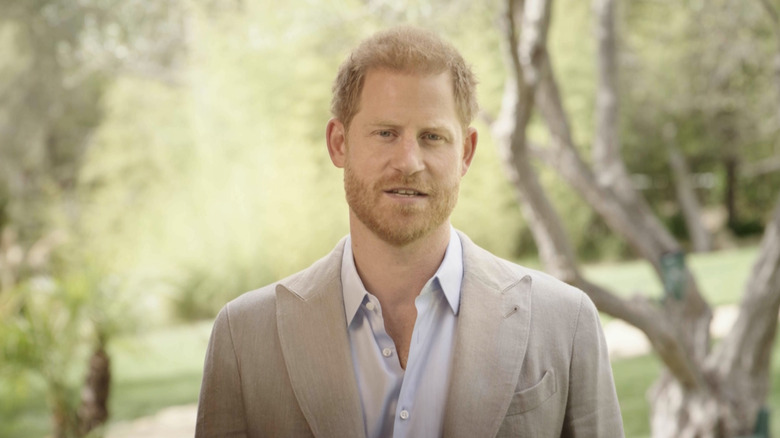 Prince Harry standing in front of trees