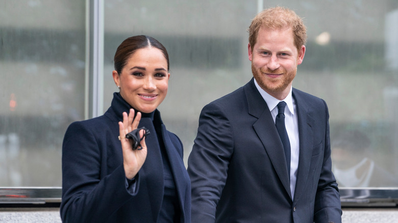 Meghan Markle and Prince Harry smiling as they walk together