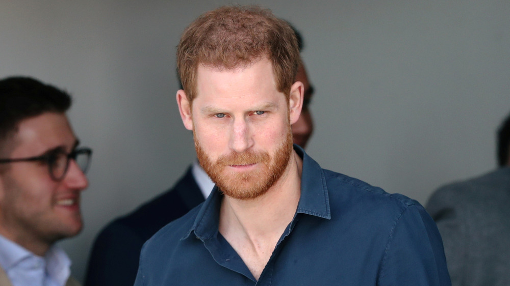 Prince Harry looking serious in the crowd