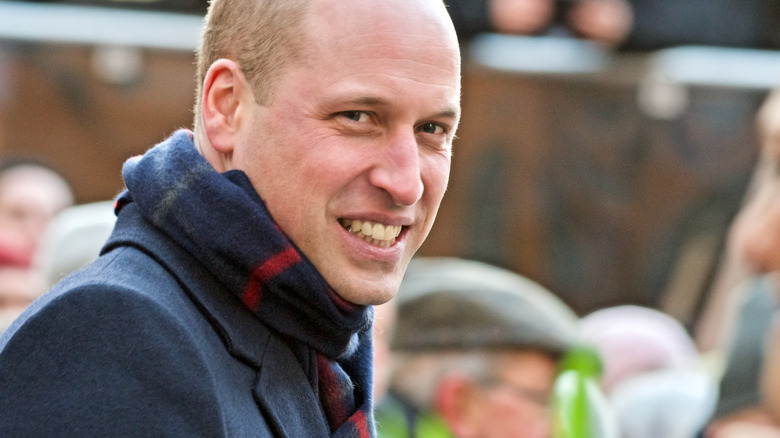 Prince William smiling and wearing scarf