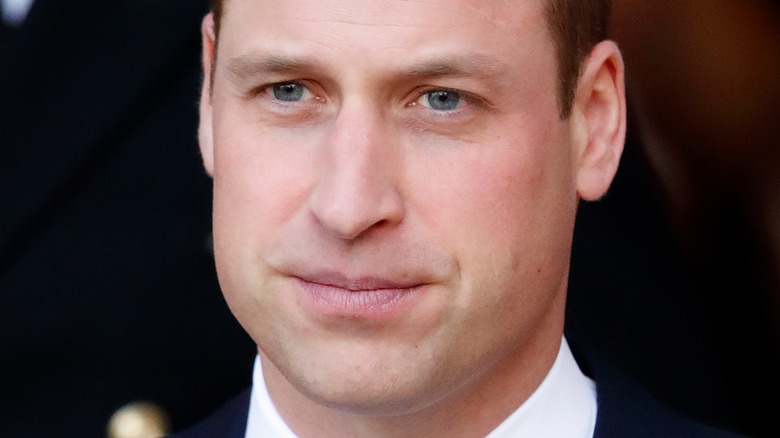 Prince William poses in a dark suit.